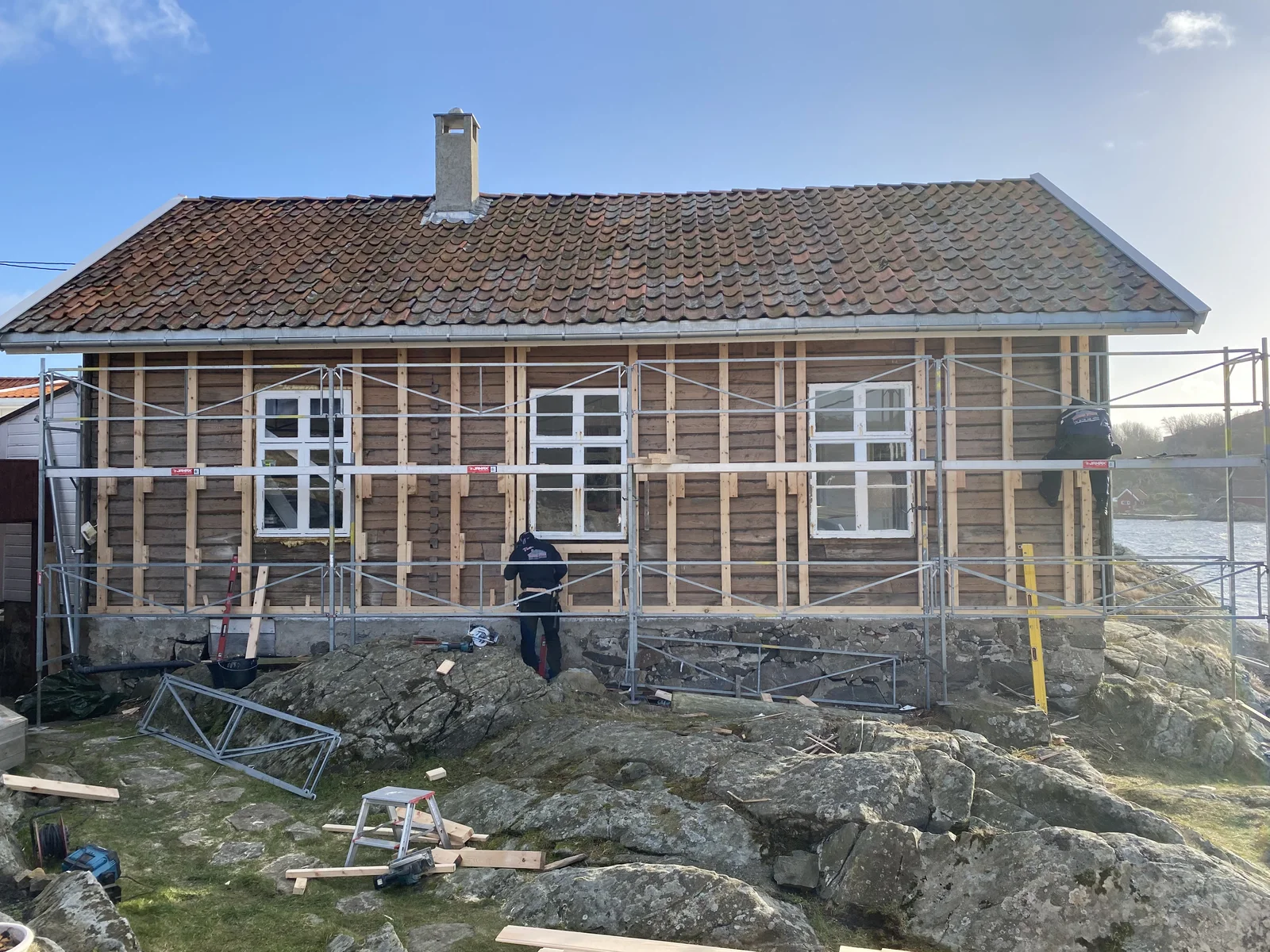 Eldre trefasade med stillas under arbeid.